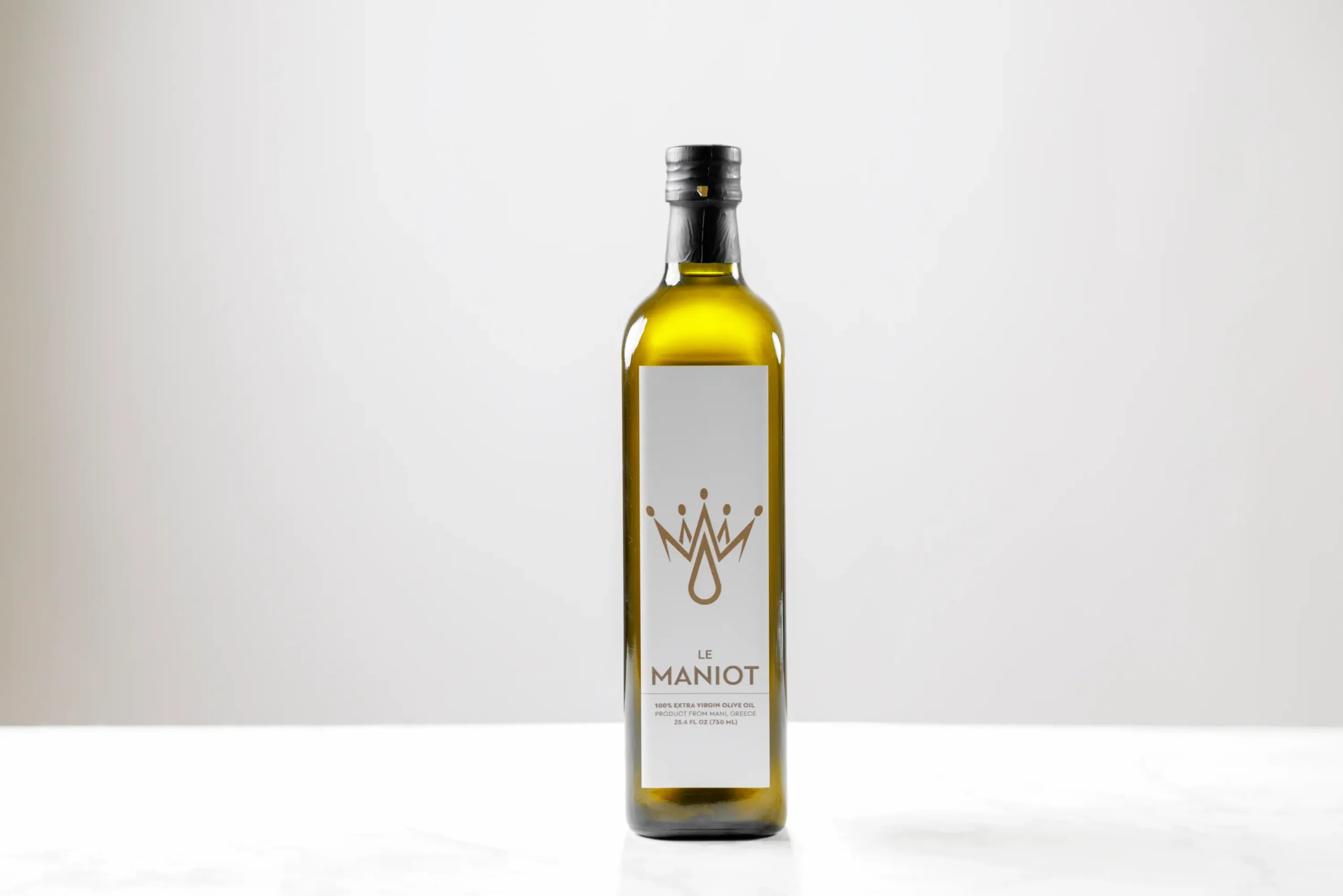 le-maniot-ancetre-heritage-750ml-bottle-3 Le Maniot L’Ancêtre 750mL bottle of unfiltered extra virgin olive oil on a white marble surface.